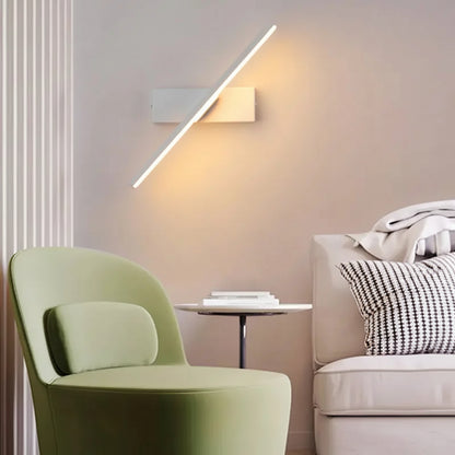 Arandela Rotativa Sereno de alumínio LED cor branca, com luz quente, instalada no canto da sala de estar, ideal para complementar a iluminação principal do ambiente