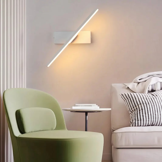 Arandela Rotativa Sereno de alumínio LED cor branca, com luz quente, instalada no canto da sala de estar, ideal para complementar a iluminação principal do ambiente