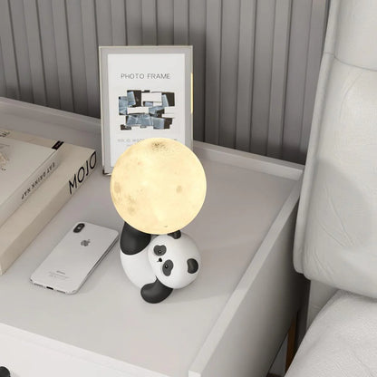 Lâmpada de Mesa Mimosa modelo panda, vista superior em mesa, estrutura compacta em resina com LED integrado, design acolhedor para cantos decorativos da casa e escritório