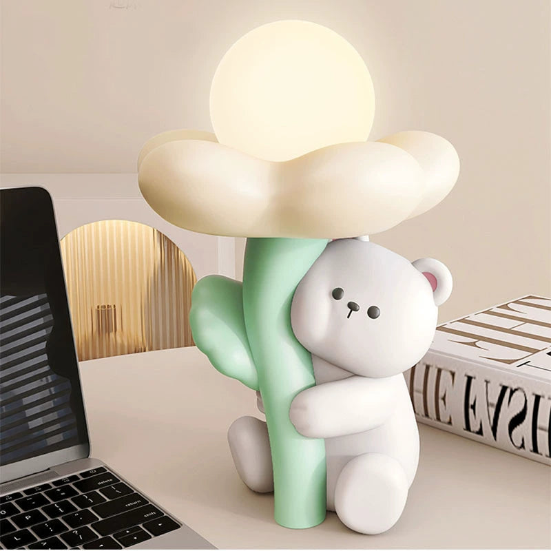 Lâmpada de Mesa Mimosa modelo urso com flor branca, instalada em mesa, estrutura em resina com LED integrado, iluminação suave para escritório doméstico e área de trabalho